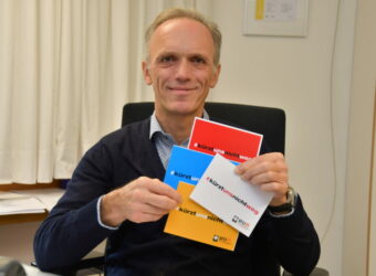 Jakob Streller mit Flyer über Kürzungen