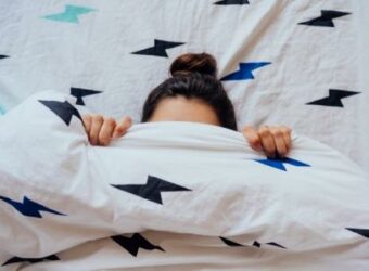 Top view of Girl. Cover of her Face with Blanket.