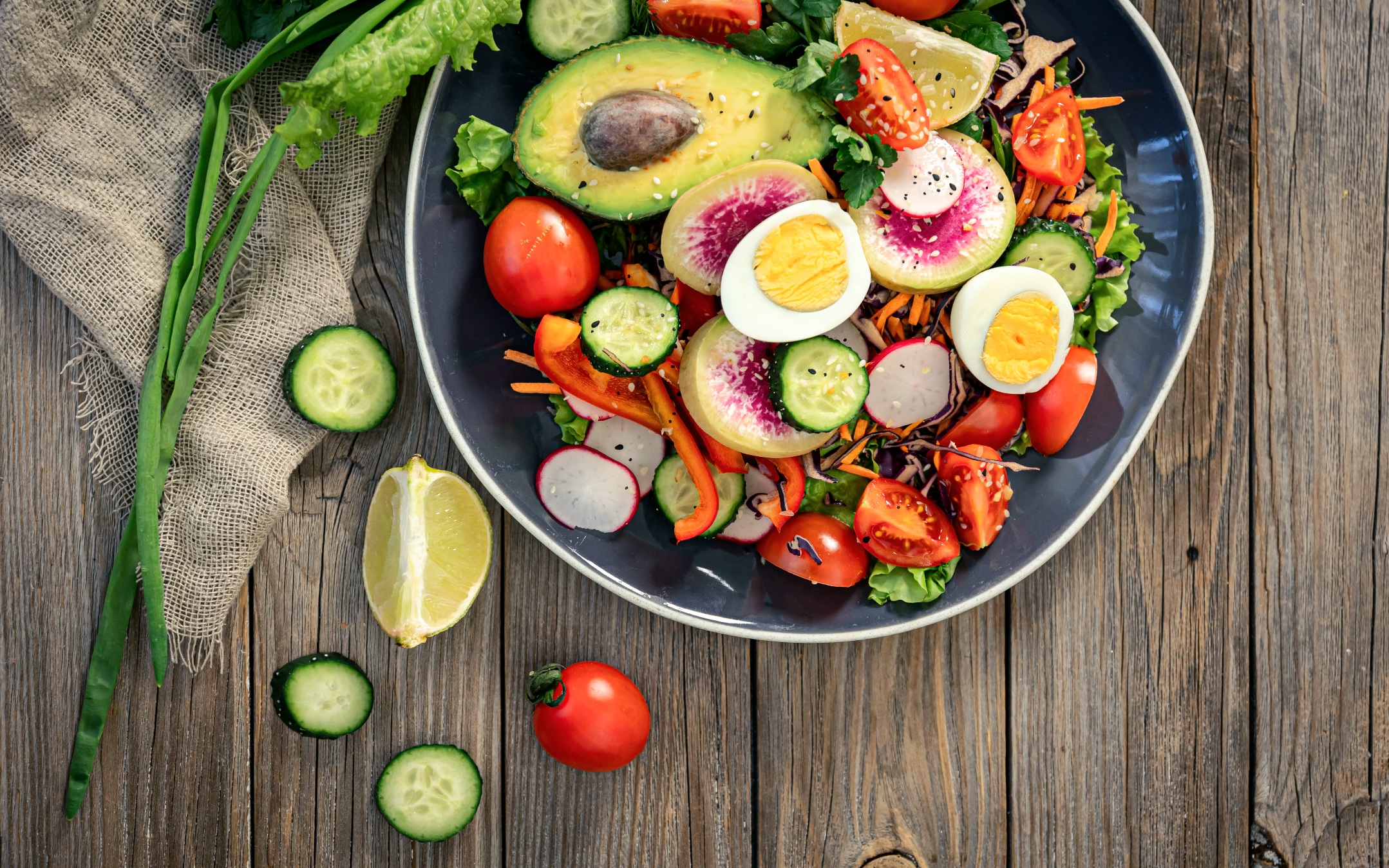 appetitlicher-gemuesesalat-mit-eiern-avocado-auf-holzhintergrund