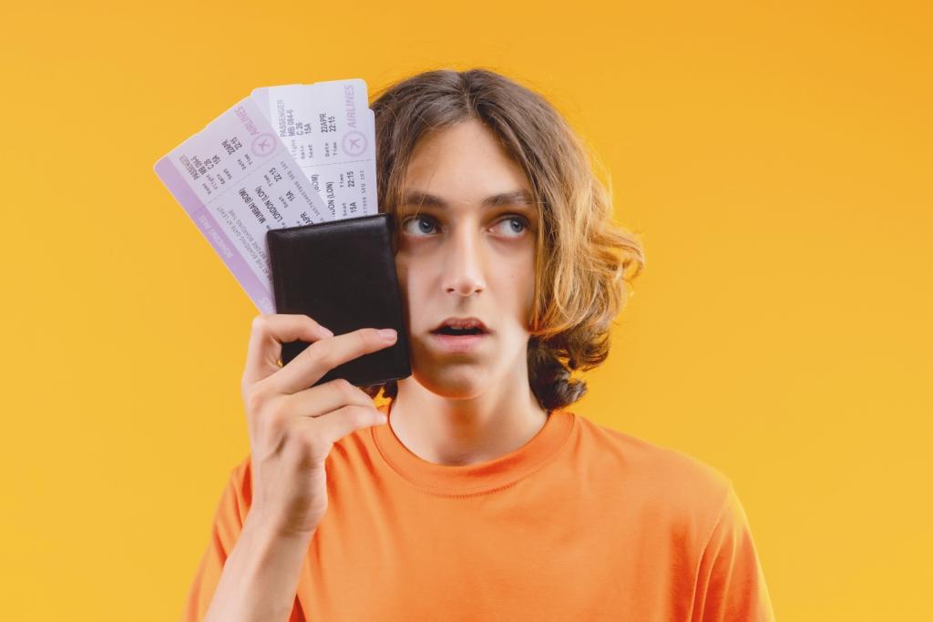 young-handsome-guy-orange-t-shirt-holding-air-tickets-looking-aside-confused-with-sad-expression (1)