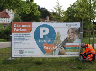Informieren über den Start des neuen Park-Systems: Sechs große Informationsbanner – hier montiert am Parkplatz Altstadt von Andreas Weidenhiller vom städtischen Bauhof. Ergänzt - 3 - werden sie von 23 Info-Schildern rund um die Parkautomaten in der Innenstadt. Fotos: Cherevko/Stadt Eichstätt