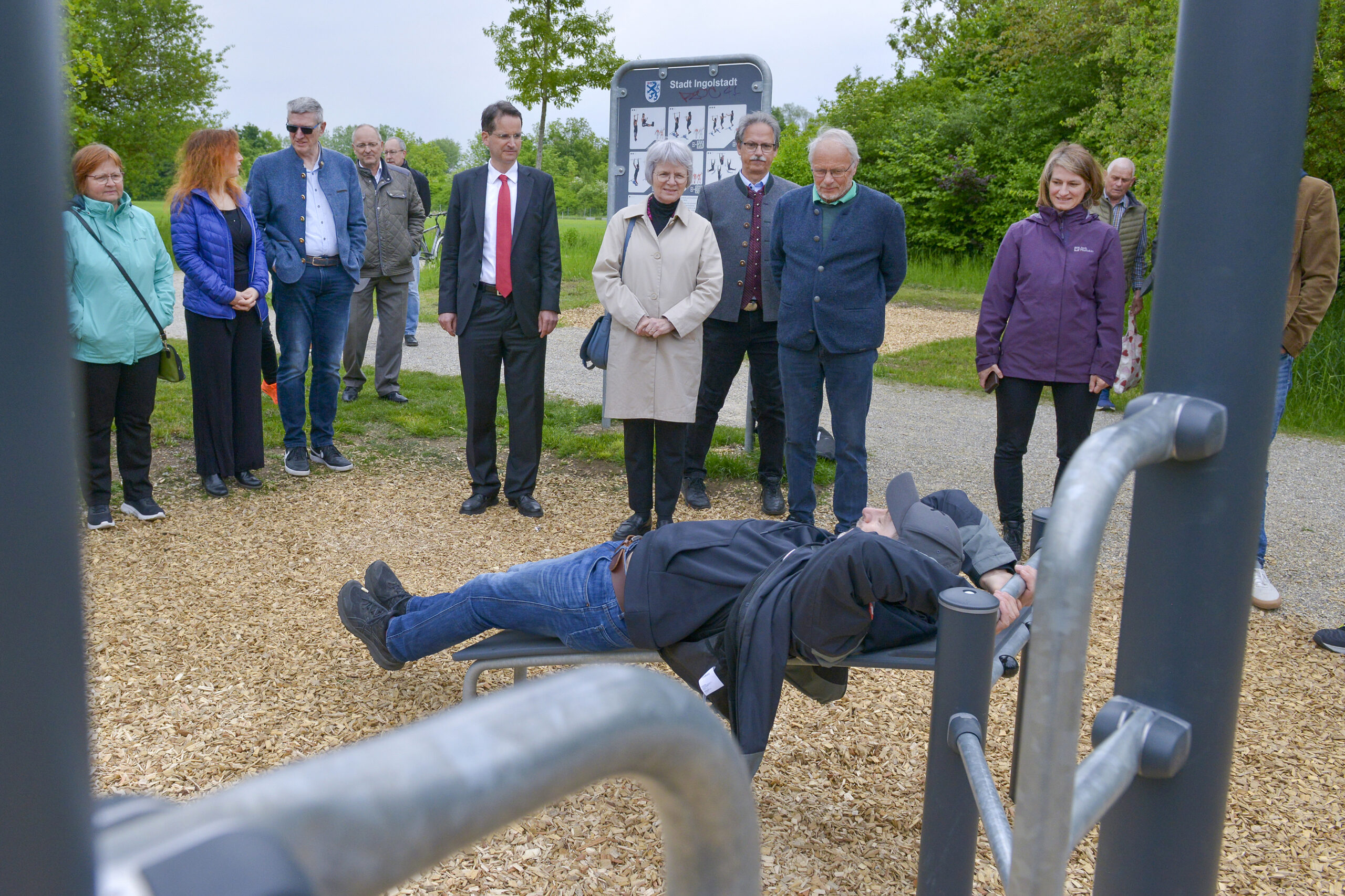 Oberbürgermeister Dr. Michael Kern und Bürger- meisterin Dr. Dorothea Deneke-Stoll übergeben gemeinsam mit Mitgliedern des Bezirksausschus- ses den neuen Bewegungspark offiziell seiner Bestimmung. Michael Aigner von der Hersteller- firma der Sportgeräte, zeigt, wie die Geräte zu bedienen sind. Foto: Stadt Ingolstadt / Rössle