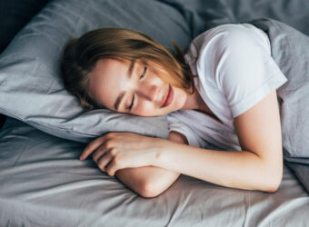 Beautiful young smiling woman sleeping in bed