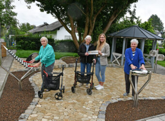 Foto: Im Caritas-Seniorenheim Ingolstadt-Gerolfing ist der Garten erneuert worden. Während Adelheid Neumaier (links) am Xylophon Harmony Glockenspiel und Edith Beringer (rechts) an der Babel Drum Spaß finden, zeigen sich Ursula Meyer und Einrichtungsleiterin Sarah Jacoby (Zweite von rechts) für die Unterstützung der GlücksSpirale dankbar. Foto: Caritas / Peter Esser