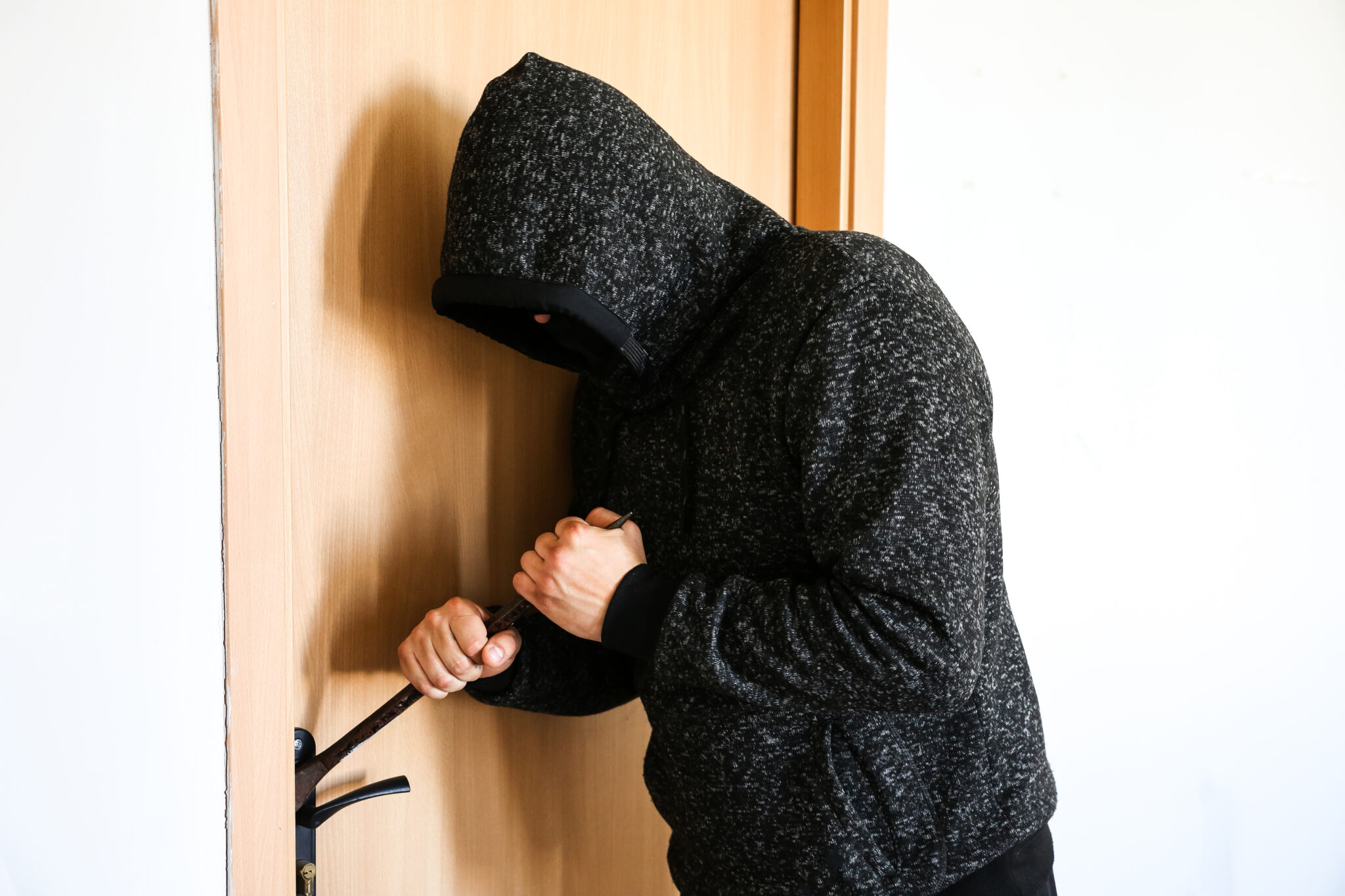 Einbruch Criminal with crowbar near the doors. Robber breaking into house