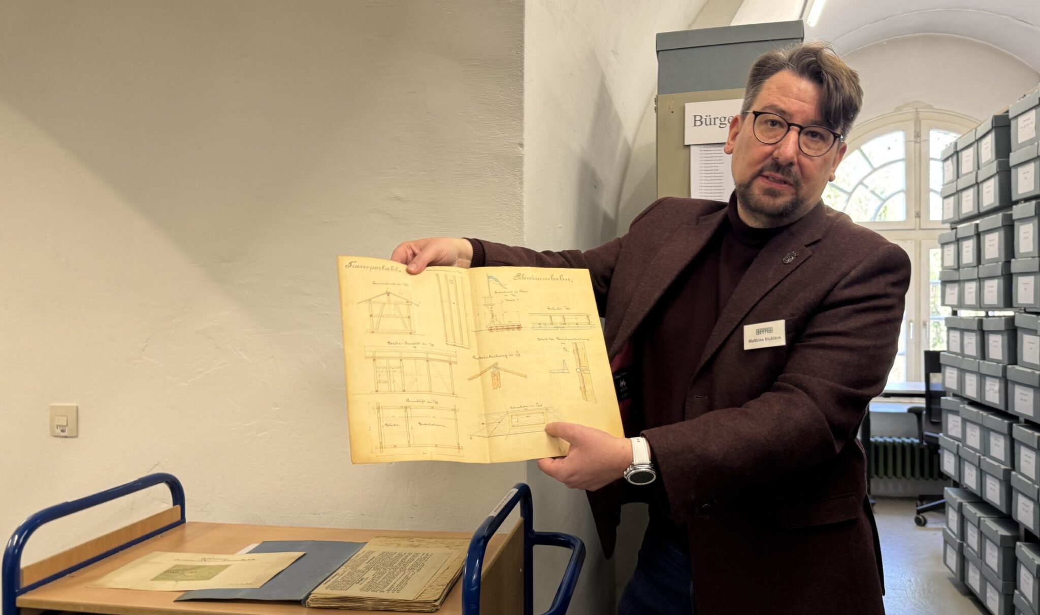 Matthias Nicklaus zeigt eine Magistratsakte zur Einrichtung eines städtischen Schwimmbades in der Donau. Die Unterlagen im Stadtarchiv sind auf 1899 bis 1935 datiert.