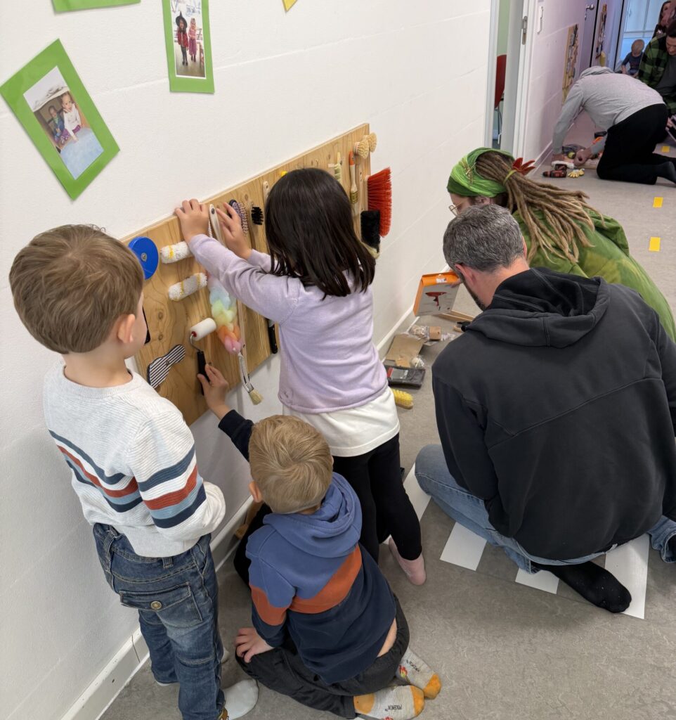 Foto-Gemeinsam für die Kleinsten: Mit viel Eifer und Geschick gestalteten die Eltern der Krippe St. Anton (Ingolstadt) gemeinsam mit ihren Kindern neue Fühlwände für die Gruppenräume. Ob am Akkuschrauber oder beim Bekleben der taktilen Elemente – der Spaß am gemeinsamen Werken stand allen Beteiligten sichtlich ins Gesicht geschrieben
