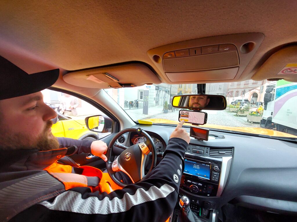 Ein Klick vor dem Losfahren reicht Maximilian Zehentmeier vom städtischen Bauhof aus. Nun erfasst sein Handy im Bauhofauto auf dem Weg zum nächsten Einsatz über die Handykamera alle Straßen und Verkehrszeichen auf dem Weg. Eine künstliche Intelligenz analysiert dann den Zustand – und gibt Bescheid, wenn ein Schlagloch gefüllt oder ein verblichenes Schild neu montiert werden muss. Doch das neue Programm kann zum Beispiel auch beim Winterdienst helfen. Foto: Sophie Fries/Stadt Eichstätt