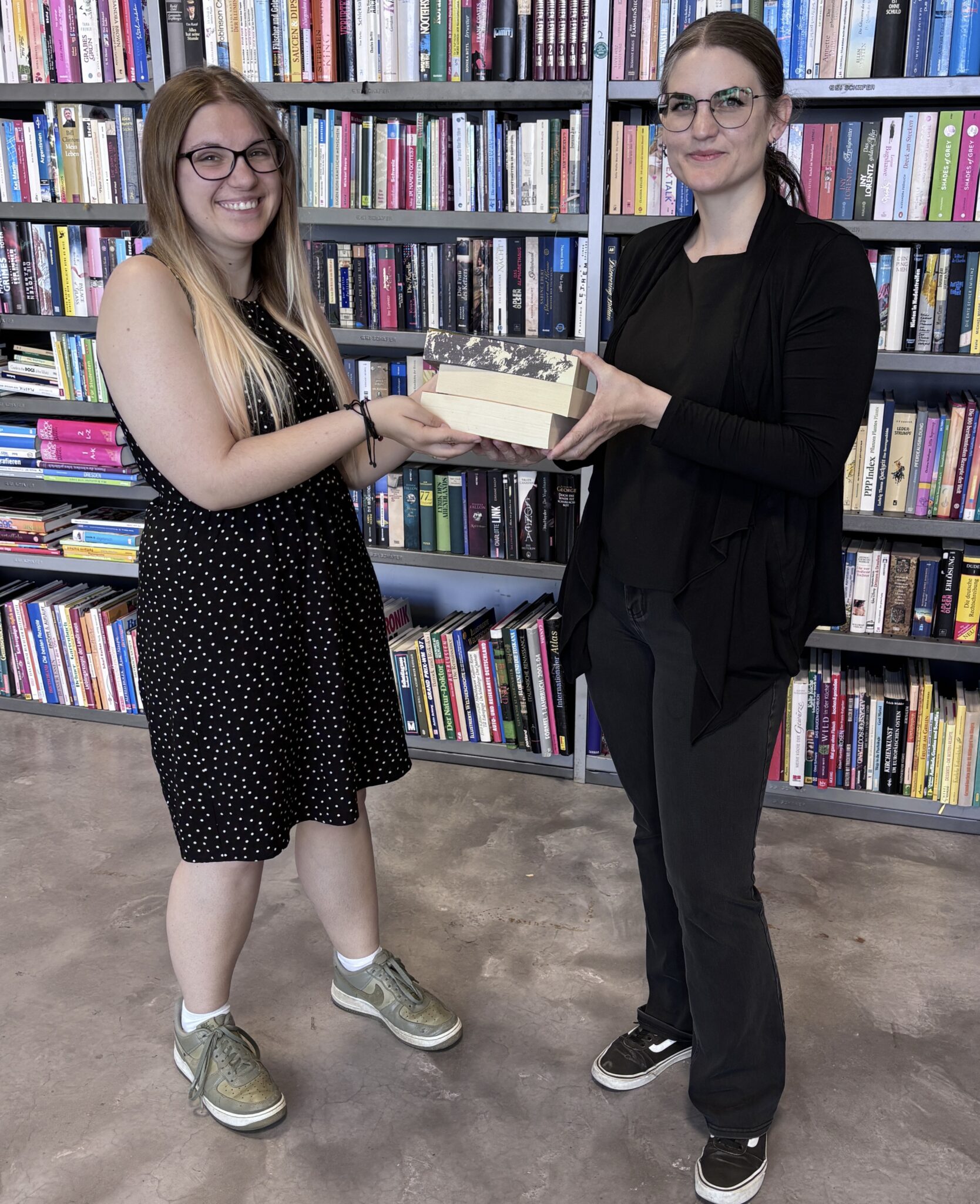 Das Team von Auwald 72, darunter Book4Good-Leiterin Lucie Lengfelder (rechts) und Teammitglied Alexandra Kreitmaier, freuen sich über viele Bücherspenden.