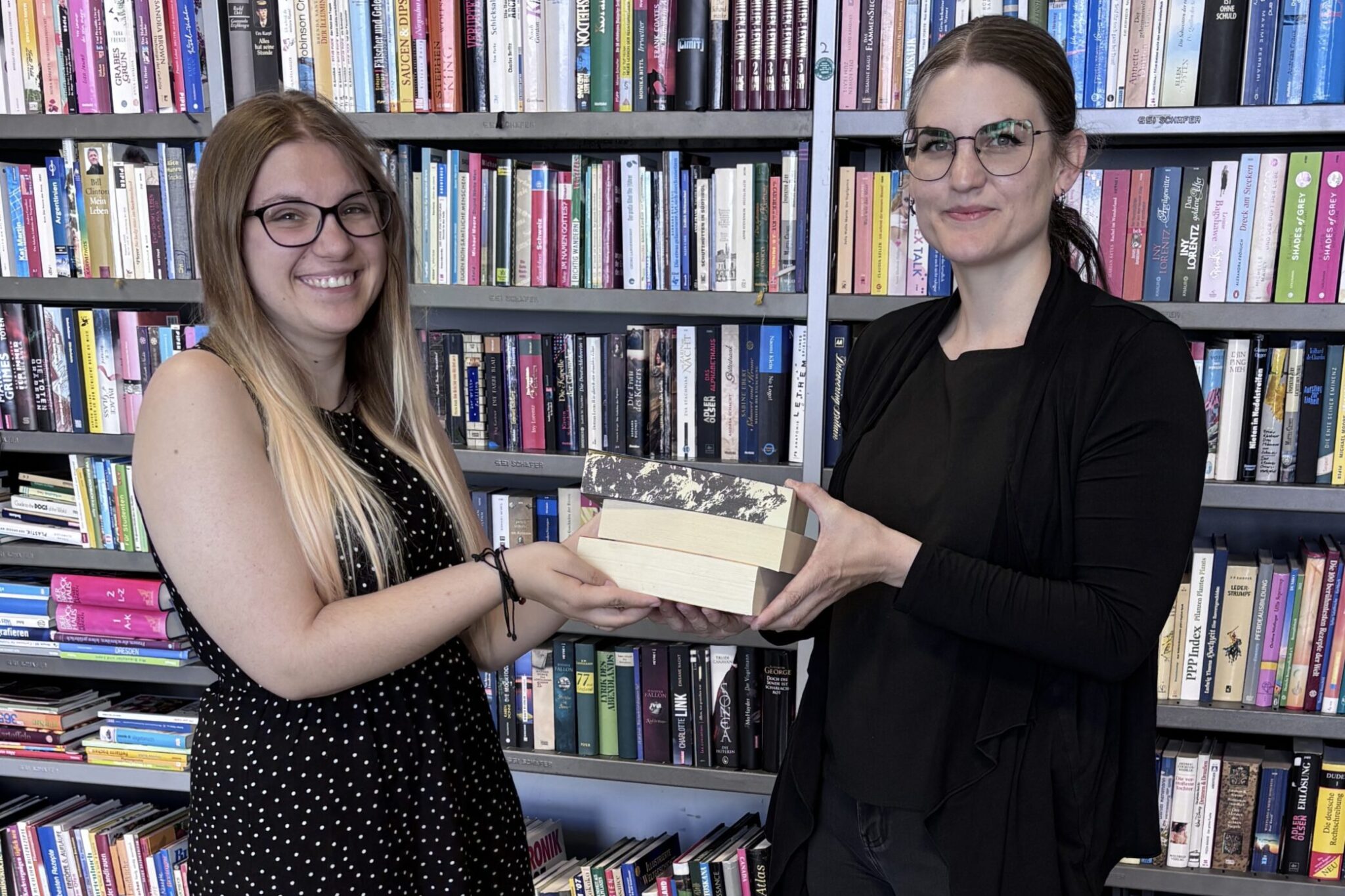 Das Team von Auwald 72, darunter Book4Good-Leiterin Lucie Lengfelder (rechts) und Teammitglied Alexandra Kreitmaier, freuen sich über viele Bücherspenden.