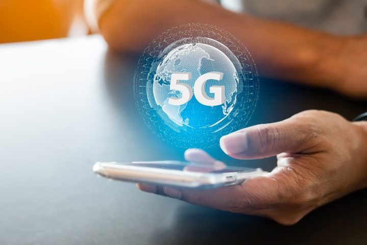 5G network digital hologram and internet of things.5G network wireless systems.Close-up of male hand typing message on mobile smartphone.