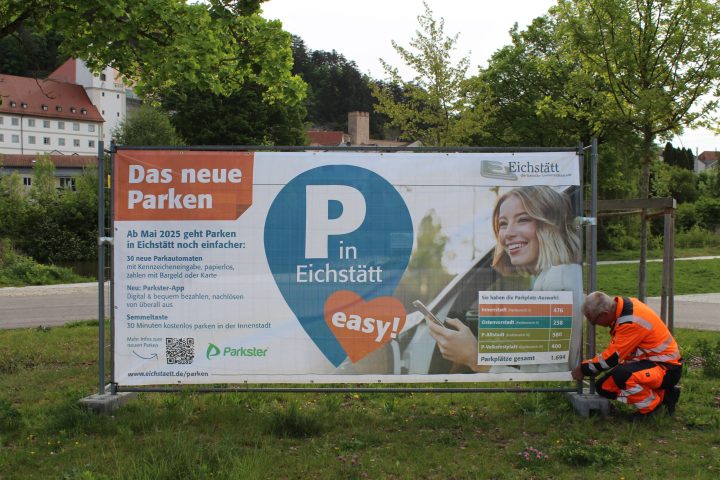 Informieren über den Start des neuen Park-Systems: Sechs große Informationsbanner – hier montiert am Parkplatz Altstadt von Andreas Weidenhiller vom städtischen Bauhof. Ergänzt - 3 - werden sie von 23 Info-Schildern rund um die Parkautomaten in der Innenstadt. Fotos: Cherevko/Stadt Eichstätt