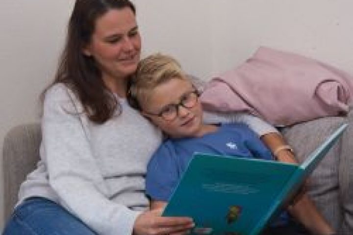 Mutter mit Sohn sitzen auf dem Sofa. Das Kind liegt im Arm der Mutter. Die Mutter liest aus einem Buch vor. Perspektive von vorne.
Foto: Studienkreis