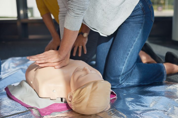 Kursteilnehmerinnen eines Erste-Hilfe-Kurses der Johanniter üben an einer Reanimationspuppe die Herzdruckmassage.
