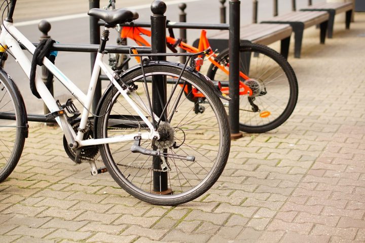A low angle closeup shot of two bicycles parked on the sidewalk