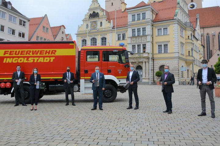 Thomas Schlagenhaufer (Einkauf & Logistik Klinikum Ingolstadt), Monika Röther (Geschäftsführerin Klinikum Ingolstadt), Dirk Müller (Leiter Führungsgruppe Katastrophenschutz), Oberbürgermeister Dr. Christian Scharpf, Dr. Siegfried Schmidtner (Leiter Audi Product Engineering), Peter Mosch (Gesamtbetriebsratsvorsitzender Audi AG) und Erhard Brandl (Projektleiter und Leiter 3D-Druck-Zentrum der Audi AG) bei der Übergabe der Gesichtsschilde auf dem Rathausplatz. Foto: Stadt Ingolstadt / Michel
