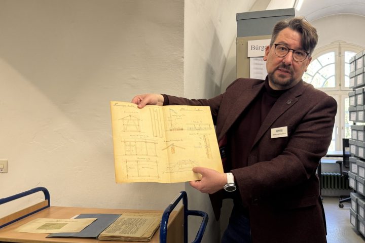 Matthias Nicklaus zeigt eine Magistratsakte zur Einrichtung eines städtischen Schwimmbades in der Donau. Die Unterlagen im Stadtarchiv sind auf 1899 bis 1935 datiert.