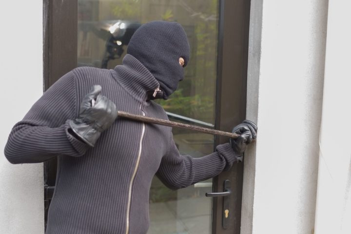 Burglar breaking door from outside with crow bar