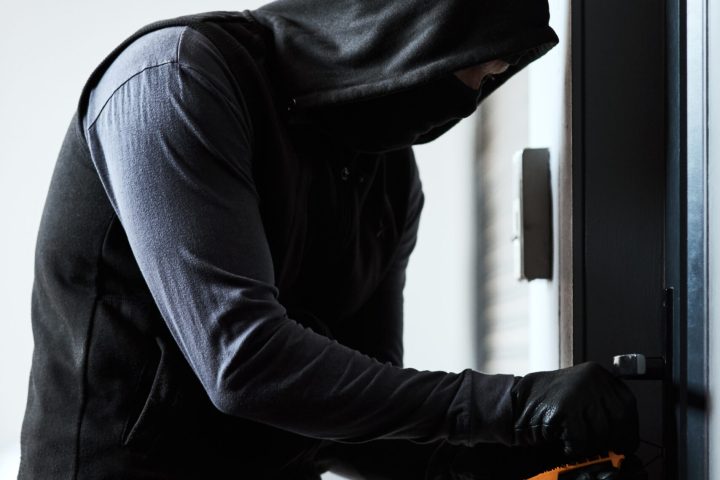 Home, door and man as criminal with tools for robbery, stealing and manipulation of lock mechanism. House invasion, thief and crime for trespass, illegal activity and sneaky person for mission.