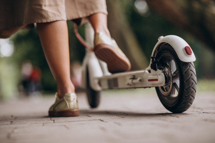 Young woman riding scooter in park feet close up