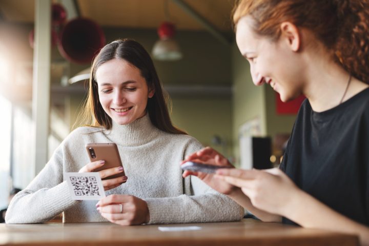young-women-scanning-qr-code-cafeteria